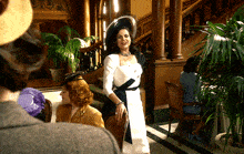 a woman in a white and black dress stands in a room