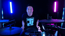 a man wearing a black shirt with the letter t on it