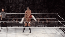 two men are wrestling in a ring with a sign that says world cup on it
