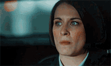 a close up of a woman 's face in a car with a serious look on her face .