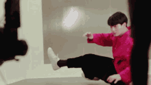 a man in a red sweatshirt is kicking his leg in the air