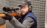 a man is holding a rifle and wearing a hat that says eagles defense