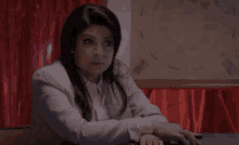 a woman is sitting at a table with her hands on her lap