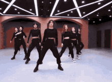 a group of women are dancing in a room with a red ceiling