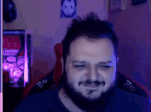 a man with a beard is smiling while sitting in a red chair .