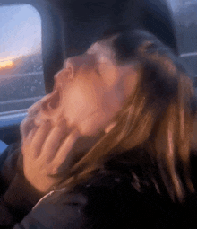 a woman is yawning in a car with her mouth open