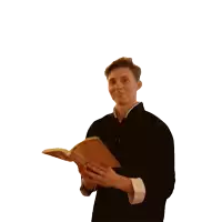 a man in a black jacket holds a book in his hands