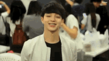 a young man with braces on his teeth is smiling in a crowd of people .