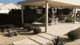 a patio area with a dining table and chairs underneath a pergola