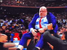 a man in a suit and tie is being lifted in the air by a fan