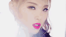 a close up of a woman 's face with bright pink lipstick .