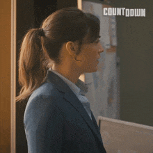 a woman stands in front of a countdown sign