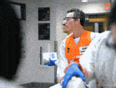 a man in an orange vest with the word emergency on it