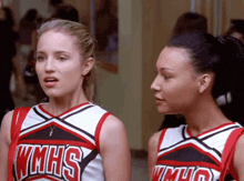 two cheerleaders from wmhs are standing next to each other in a hallway