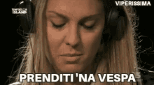 a woman wearing headphones is talking into a microphone and making a funny face .