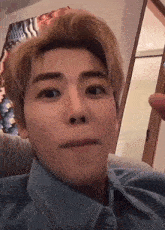 a close up of a person making a funny face while sitting on a couch in a room .