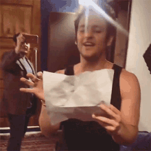 a man is holding a piece of paper in his hands