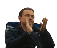 a man in a blue shirt is clapping his hands
