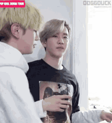two men are standing next to each other in a room .