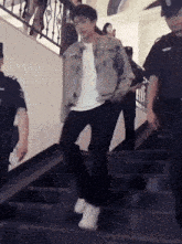a man is walking up a set of stairs with a group of people behind him .