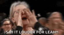 a woman is covering her face with her hands and screaming in a crowd .