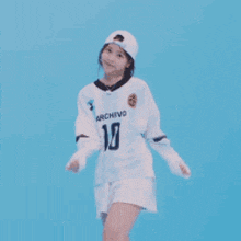 a woman wearing a white shirt with the number 10 on it is dancing