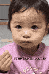 a little girl wearing a pink shirt that says saso on it