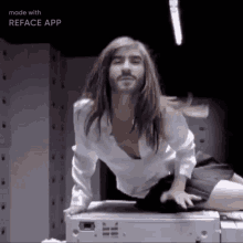 a man with long hair and a beard is kneeling on a printer ..