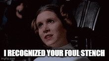 princess leia from star wars is sitting in a chair and saying `` i recognized your foul stench ''