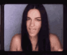 a close up of a woman 's face with long black hair
