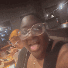 a blurry photo of a woman wearing glasses and a necklace