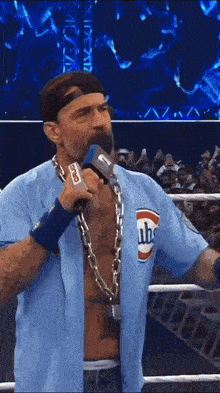 a man with a chain around his neck is holding a microphone with the words before you go below him