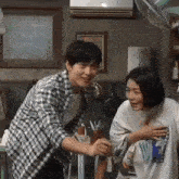 a man in a plaid shirt is standing next to a woman