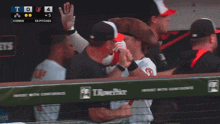a baseball player wearing a pirate hat high fives another player in a dugout