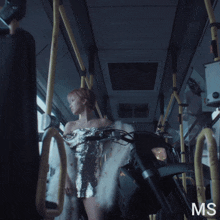 a woman in a sequined dress is standing next to a black motorcycle with the letters ms on the bottom