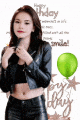 a woman in a leather jacket is standing next to a green balloon and the words happy birthday