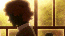 a man is standing in front of a window and looking out .