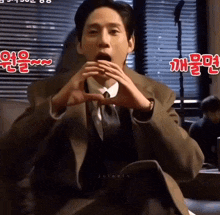 a man in a suit and tie is sitting on a couch and making a funny face