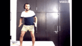 a man wearing headphones is dancing on a bed with the word veed.i on the bottom
