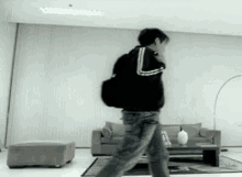 a person walking in a living room with a couch and ottoman