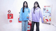 two girls standing in front of an idn machine