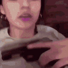 a woman is holding a video game controller in her hands .