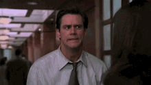 a man in a striped shirt and tie is making a funny face