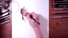 a person is drawing a picture of a woman 's face with prismacolor pencils