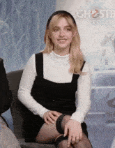 a woman is sitting in front of a ghostbusters frozen poster