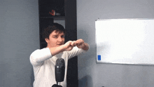 a man is standing in front of a microphone and a white board