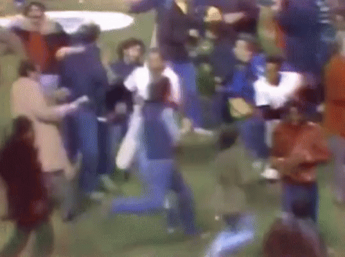 a blurry picture of a crowd of people dancing in a field