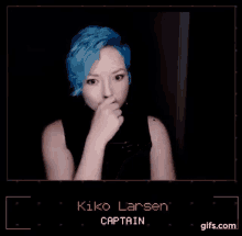 a woman with blue hair is wearing a black shirt and making a face .