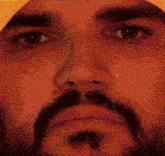 a close up of a man 's face with a beard and a yellow hat