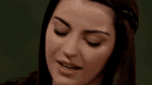 a close up of a woman 's face with her eyes closed and a serious look on her face .